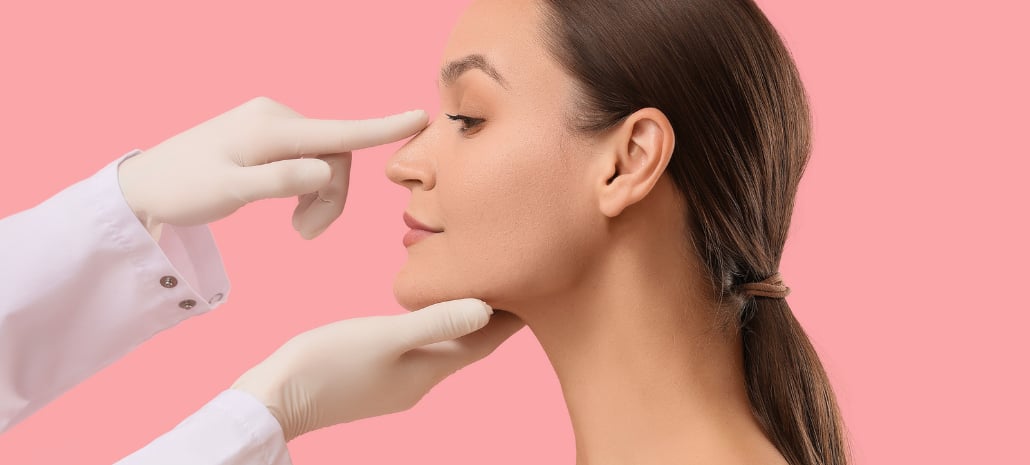 Doctor examining a patient's nose profile, relating to nose surgery and computer imaging consultations