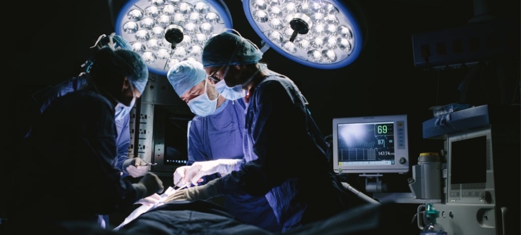 Surgeon performing a procedure in the operating theatre, illustrating the process behind en bloc breast implant removal