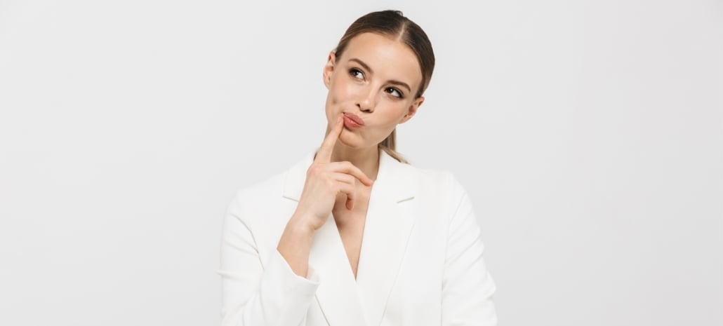 Thoughtful woman weighing her options, representing the decision between breast implants and fat transfer