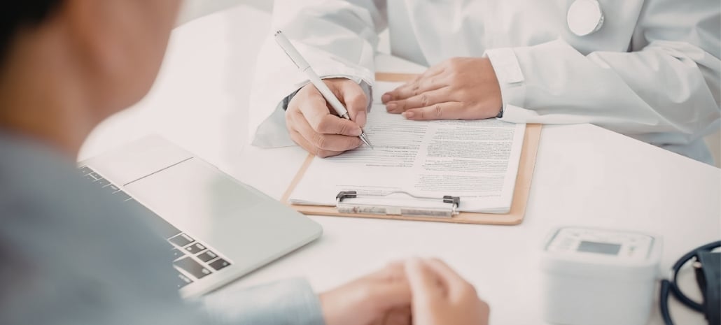 Doctor and patient reviewing consultation notes, representing key questions to ask before breast implant surgery