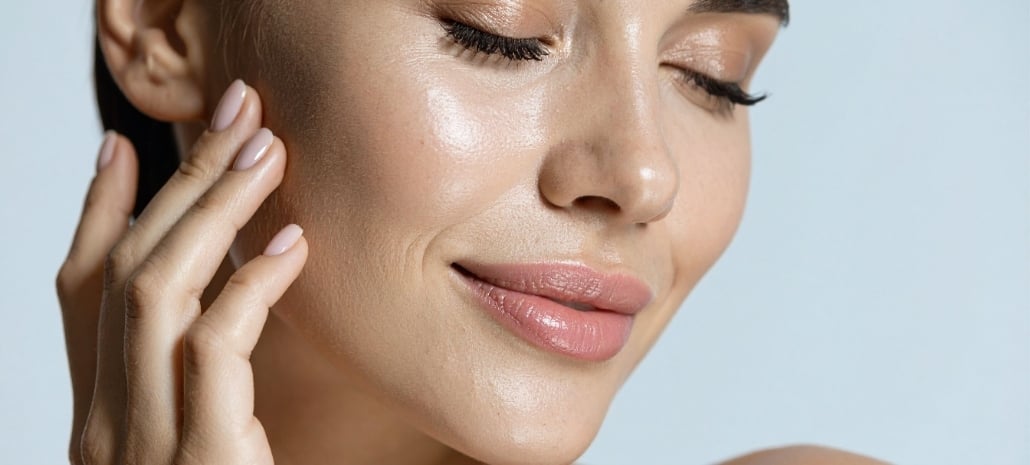Close-up of a woman's face highlighting smooth skin and full lips after facial fat transfer