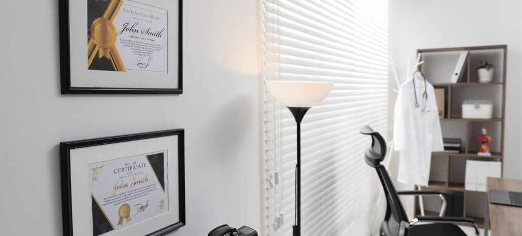 Framed medical certificates on the wall of a qualified surgeon's office